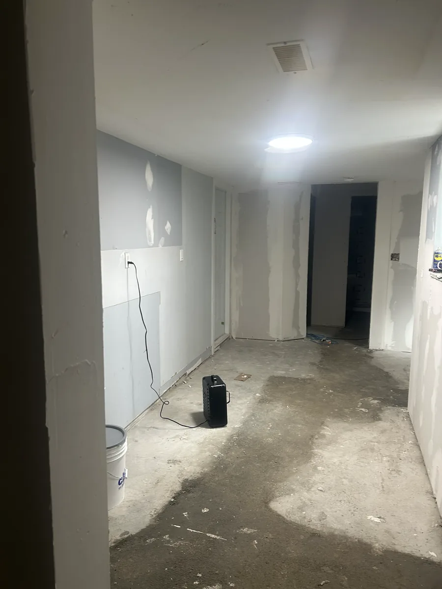 Interior room with taped drywall, ceiling lighting, and an unfinished floor.
